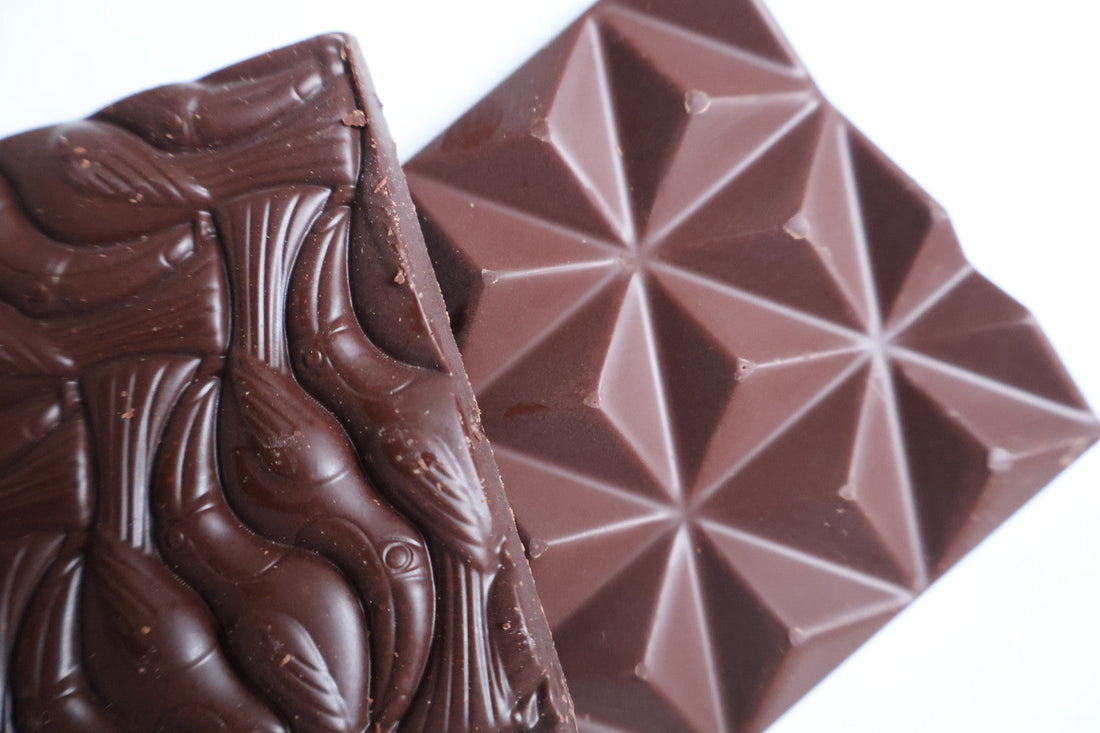 2 different chocolate bars lying on top of each other showing different colour and texture